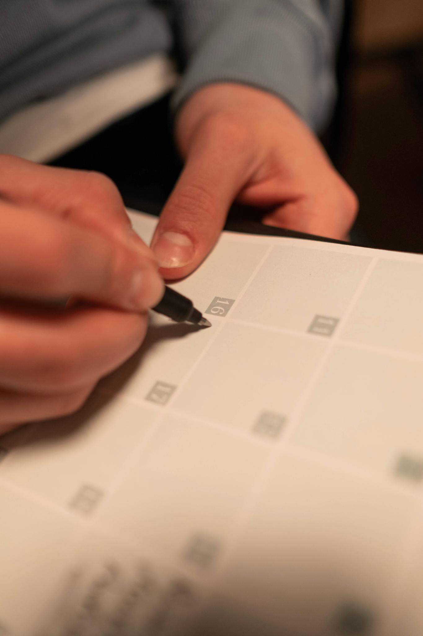 Pricing Close-up of a hand writing on a calendar, planning future events.